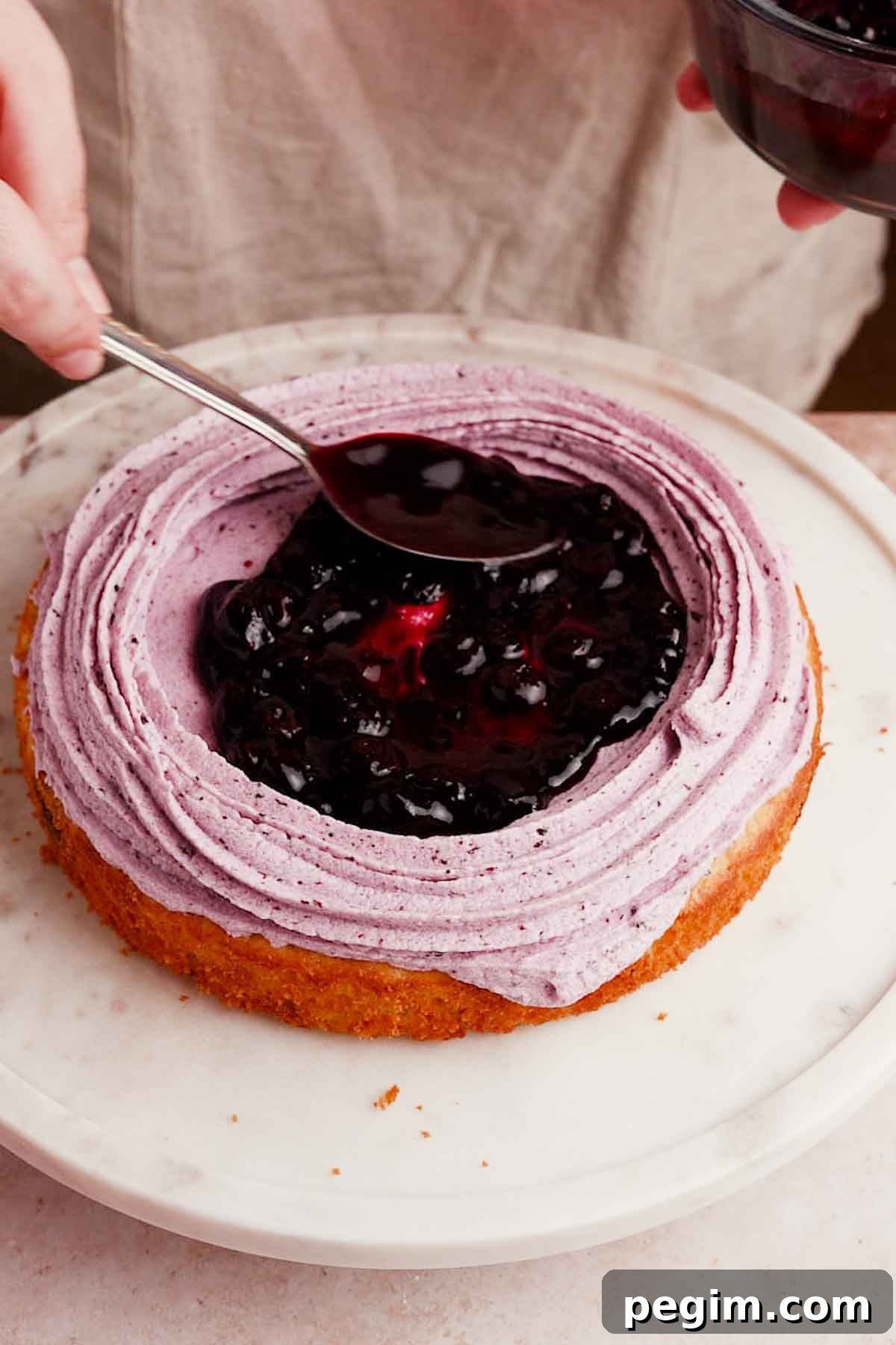 Blueberry Birthday Cake Recipe — Moist Layer Cake for Parties 14 adding blueberry filling into middle of blueberry cake
