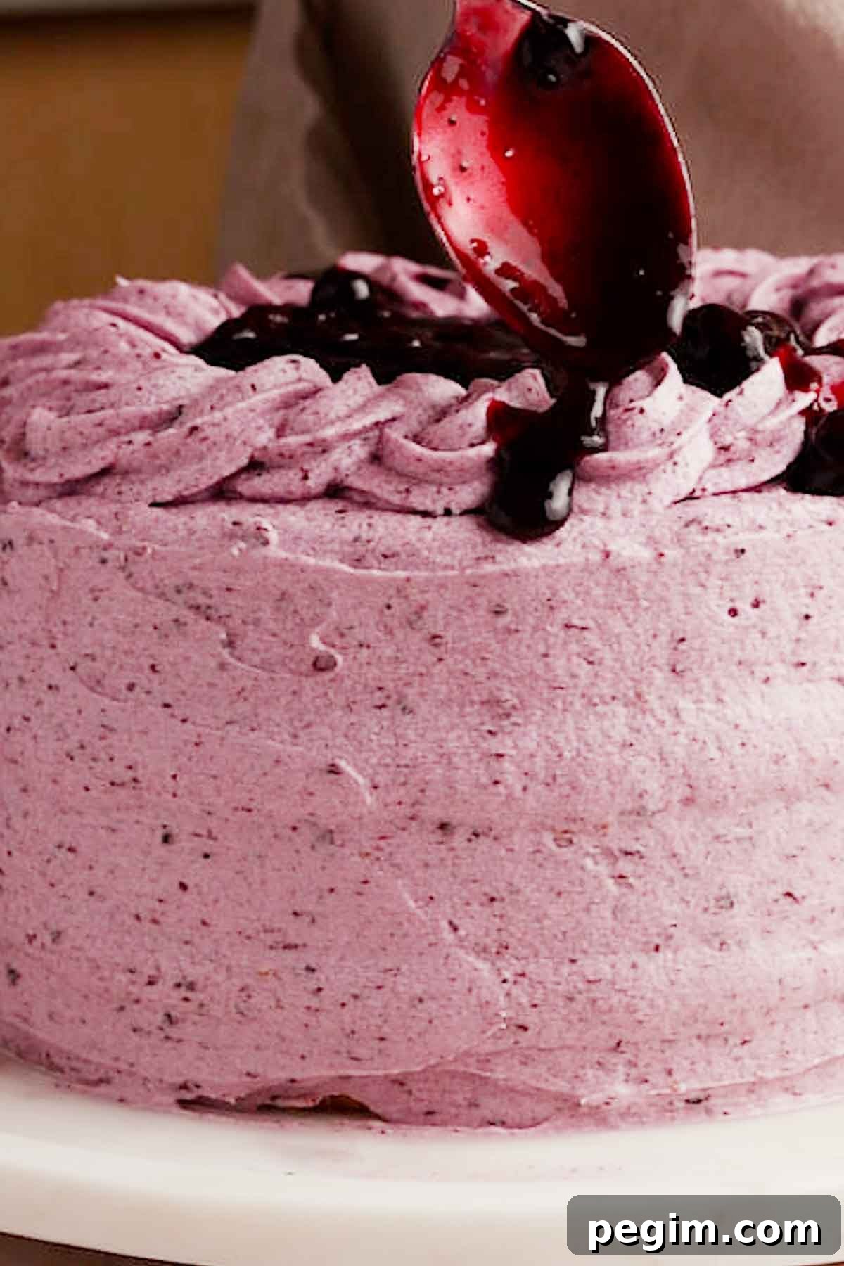 Blueberry Birthday Cake Recipe — Moist Layer Cake for Parties 18 adding drips of blueberry filling on top of the cake
