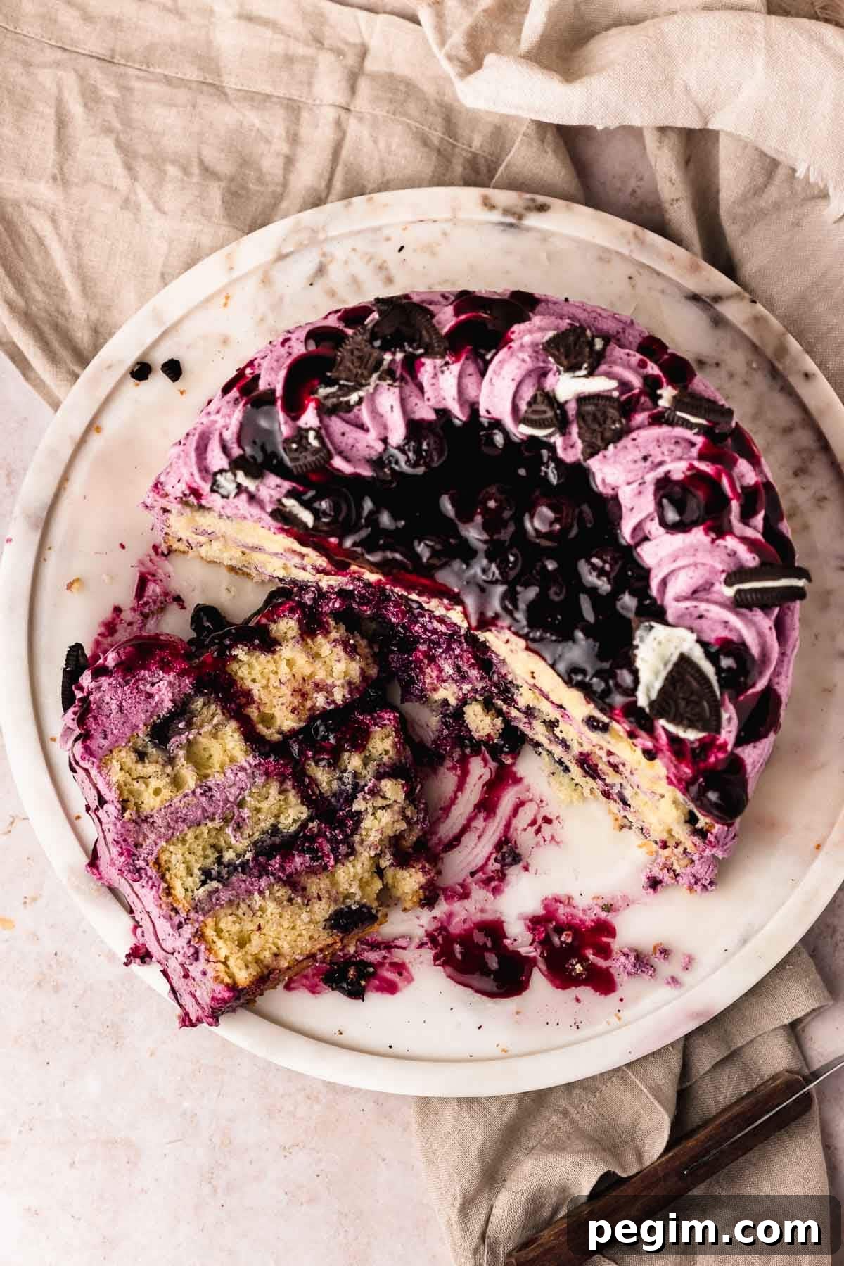 Blueberry Birthday Cake Recipe — Moist Layer Cake for Parties 20 Cut blueberry cake with slice on marble cake plate