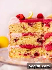 cross section of lemon raspberry layer cake with gooey raspberry curd filling
