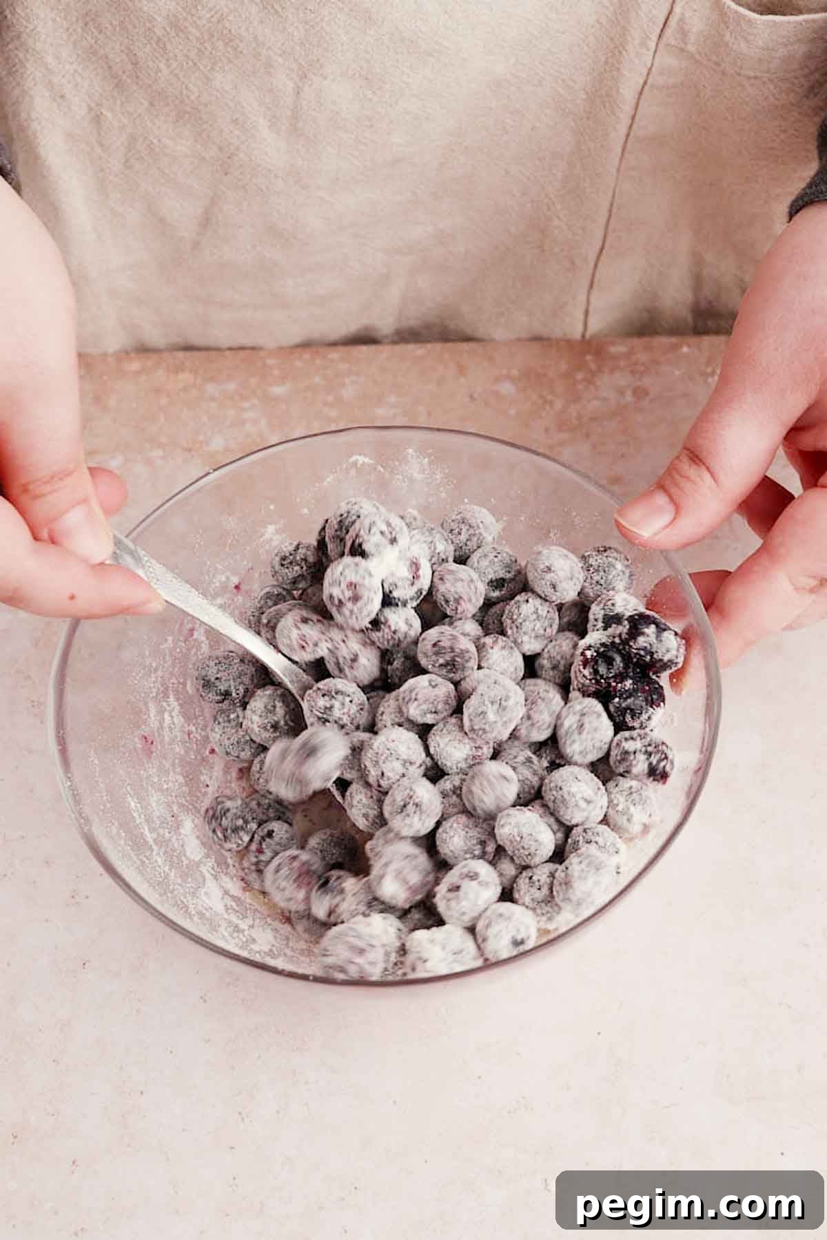 Blueberry Birthday Cake Recipe — Moist Layer Cake for Parties 7 coating blueberries in flour in a small bowl