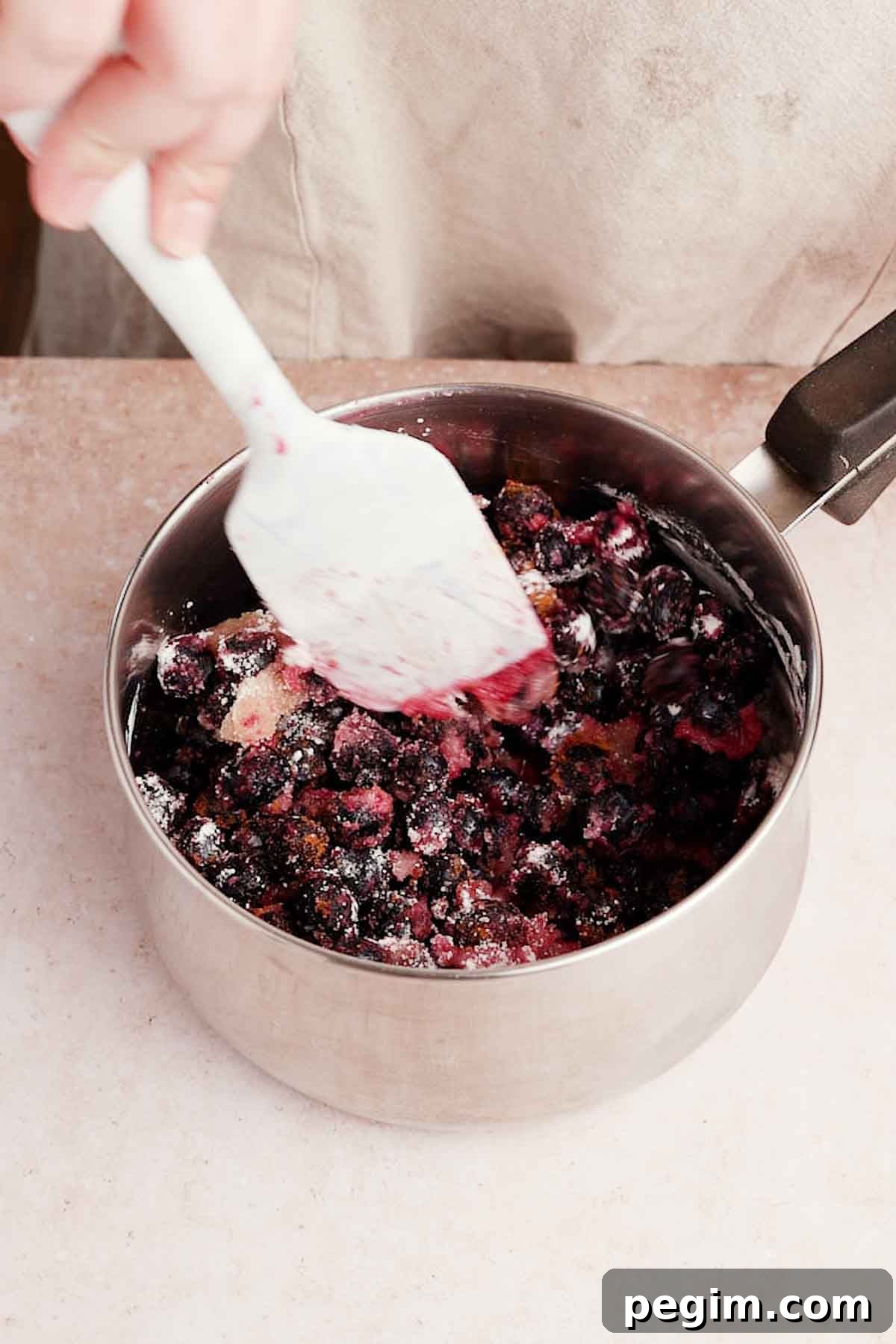 Blueberry Birthday Cake Recipe — Moist Layer Cake for Parties 9 stirring frozen blueberries, sugar, lemon juice, and cinnamon in a small saucepan for filling