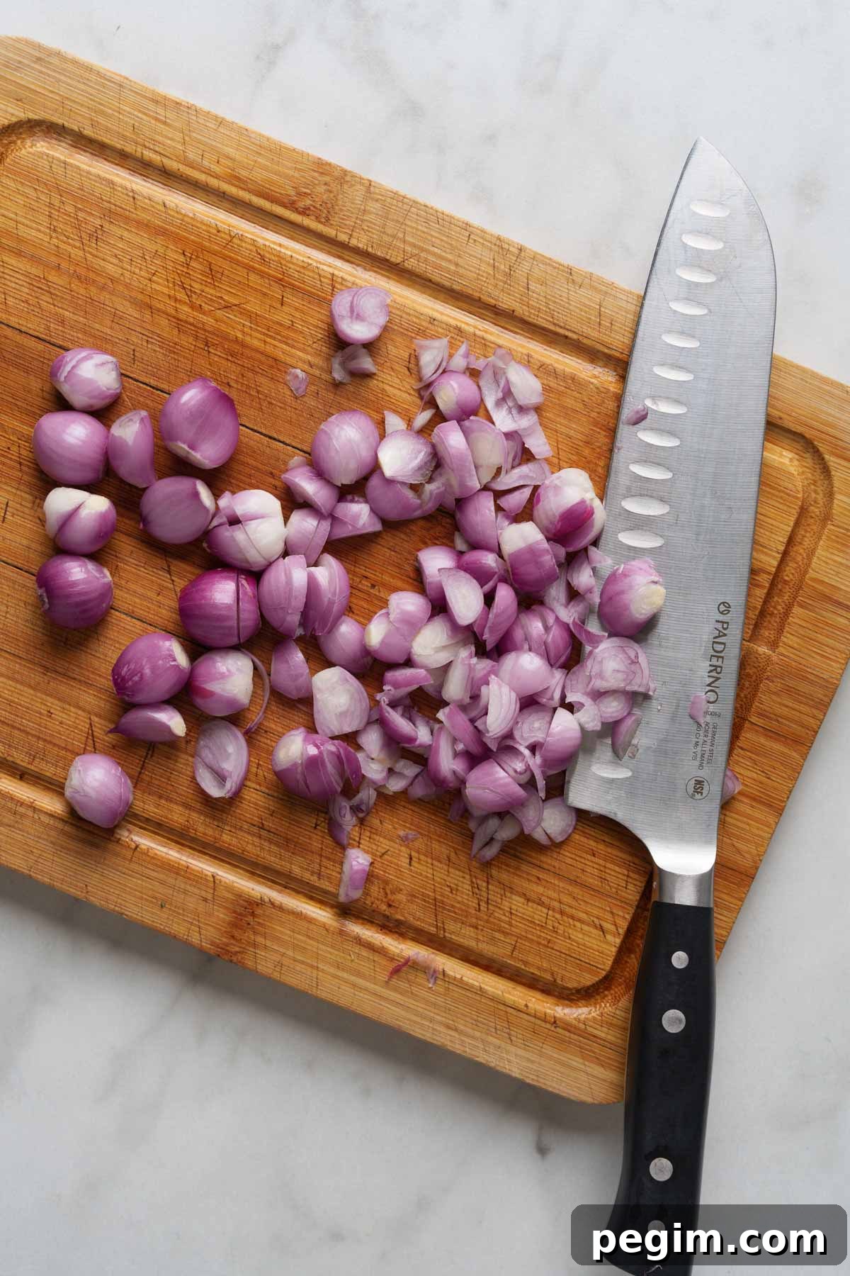 Lunu Miris: Authentic Sri Lankan Chilli and Onion Sambal 4 shallots, peeled and sliced on a cutting board.