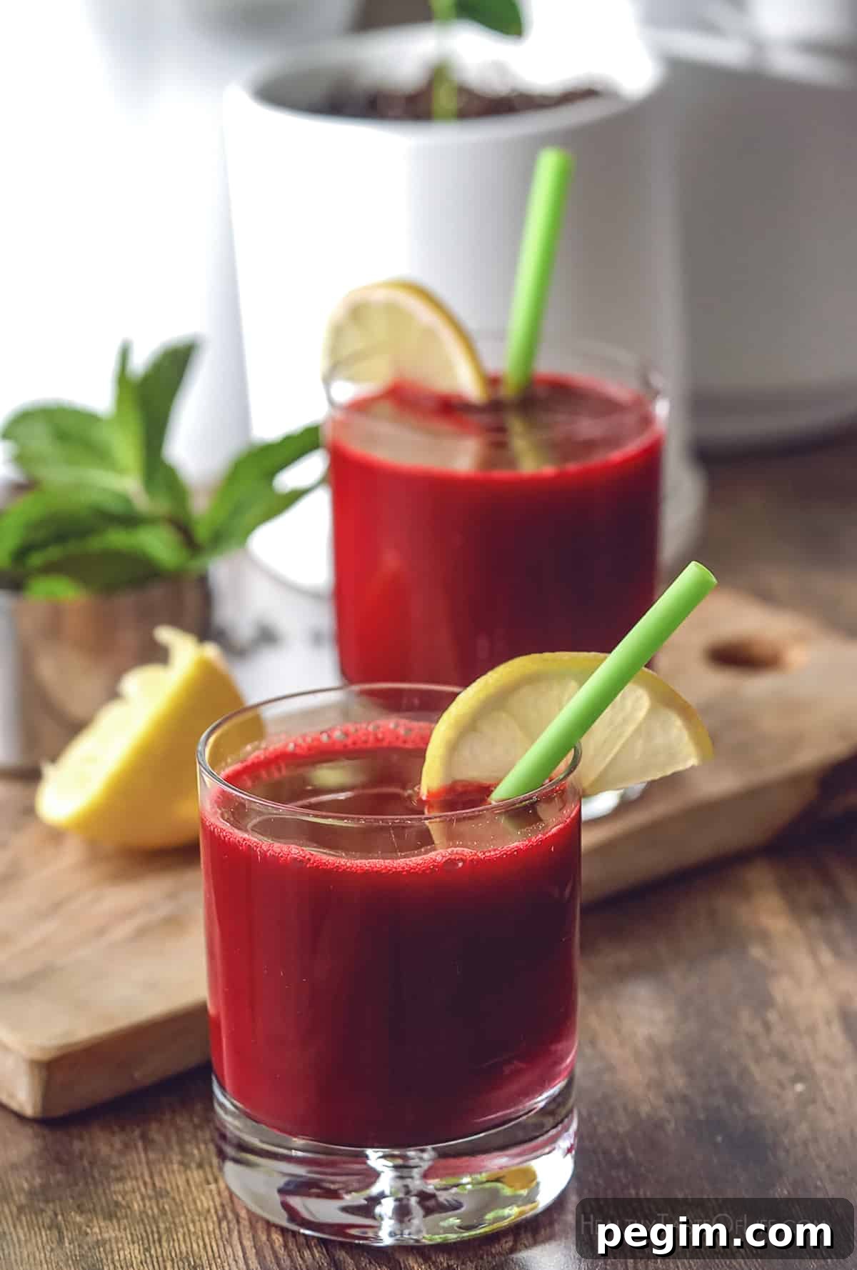 Beetroot Juice Recipes: 2 Ways and Flavor Pairings 12 Freshly juiced beetroot juice served in a glass with a lemon wedge and a straw.