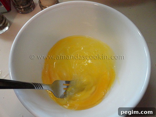 homemade-chicken-nuggets-step-5 A white bowl filled with whisked eggs