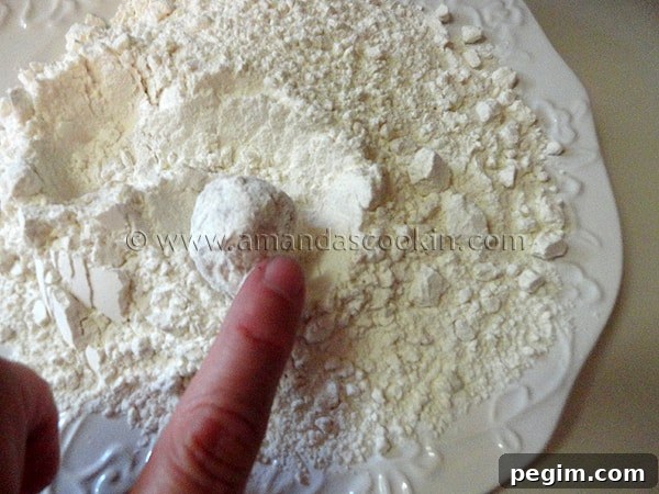 homemade-chicken-nuggets-step-9 A photo of chicken ball being rolled in flour.