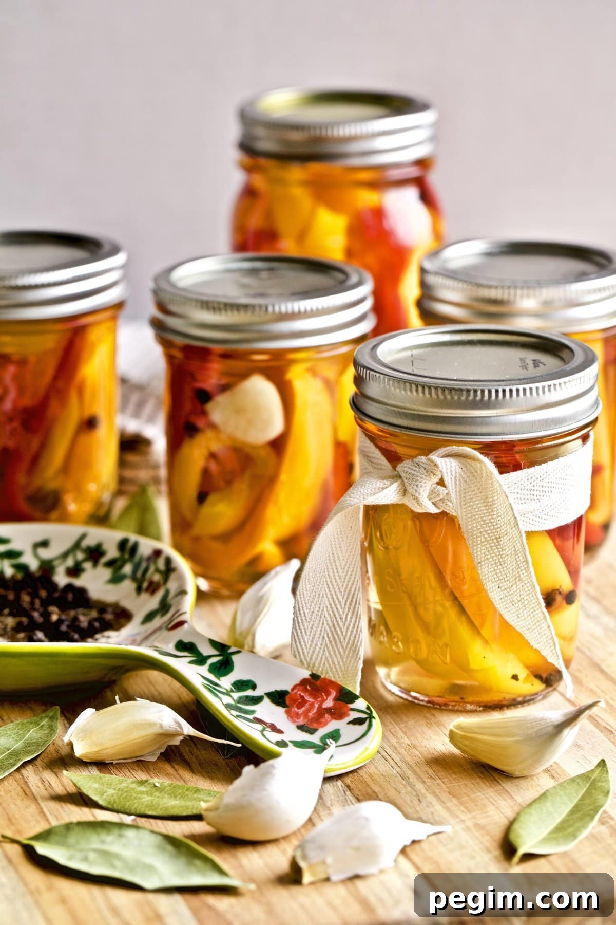 Classic Italian Pickled Peppers Recipe 2 Italian vinegar peppers in a jars with ingredients and serving spoon with ingredients