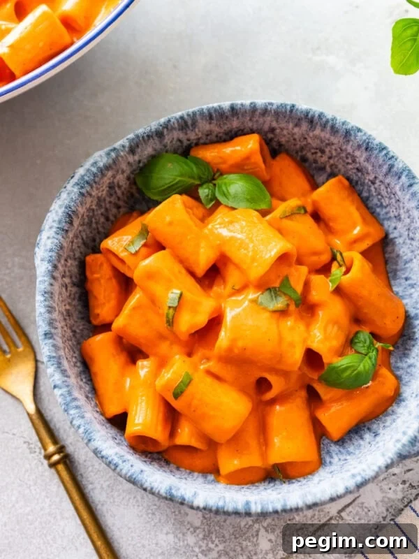 Classic Italian Pickled Peppers Recipe 12 Roasted red pepper pasta in a bowl topped with basil and a fork on its side.