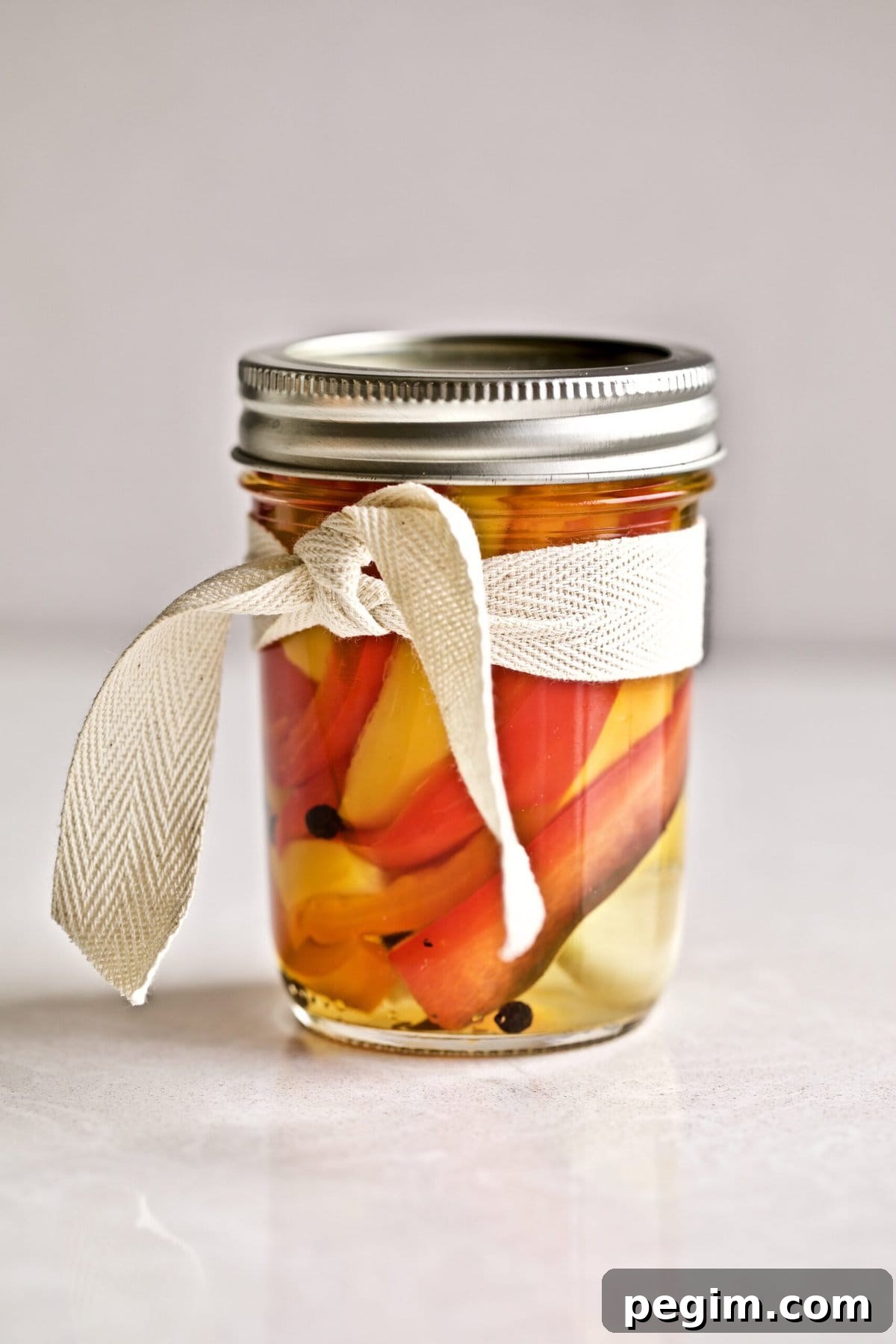 Classic Italian Pickled Peppers Recipe 9 Jar of pickled Italian vinegar peppers tied with a ribbon.