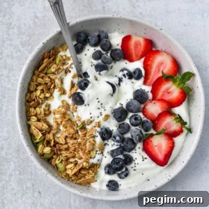 Cottage Cheese with Fruit: Tasty Breakfast and Snack Ideas 17 A spoon dipped into cottage cheese with fruit, granola, and seeds.
