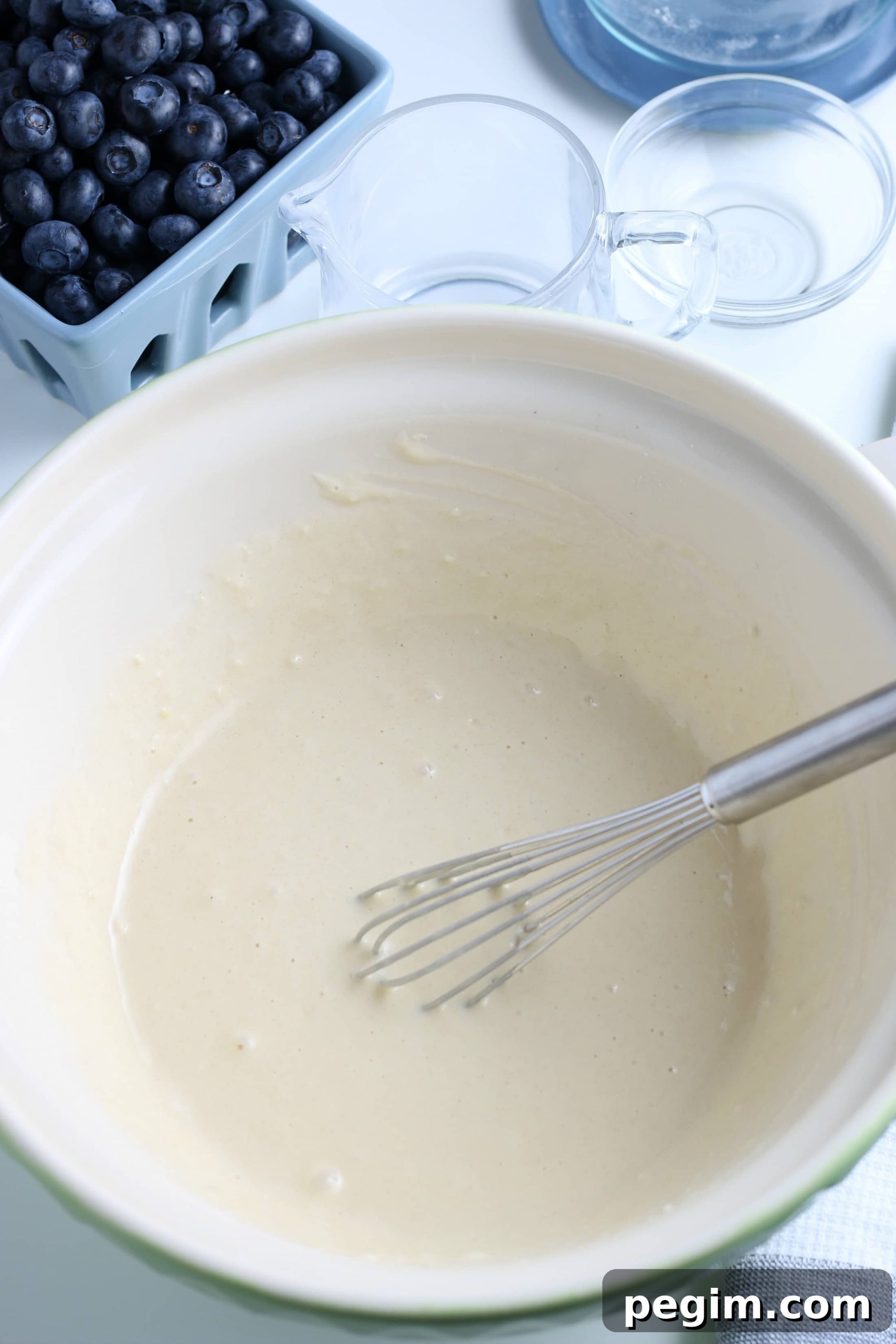 Fluffy Homemade Blueberry Pancakes 5 mixed pancake batter in a white glass bowl