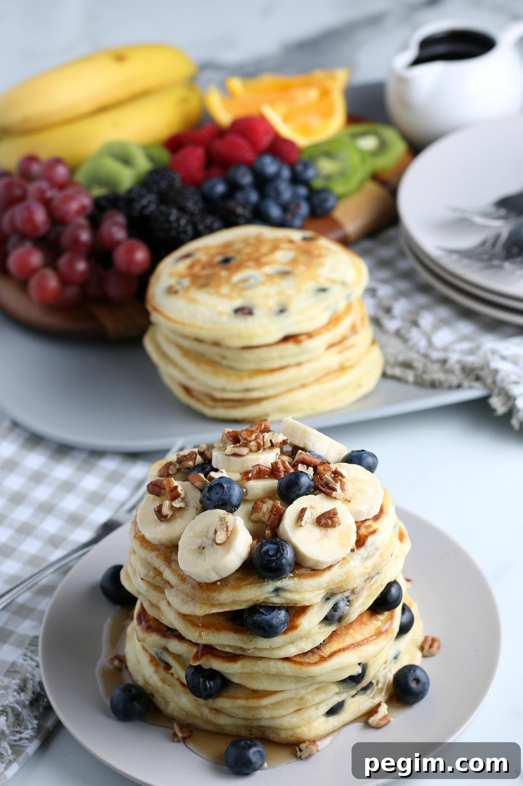 Fluffy Homemade Blueberry Pancakes 7 A stack of blueberry pancakes with fruit in the background.