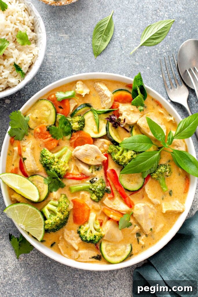 Authentic Thai Chicken Curry with Coconut Milk 2 A bowl filled with Thai chicken curry with vegetables garnished with fresh herbs.