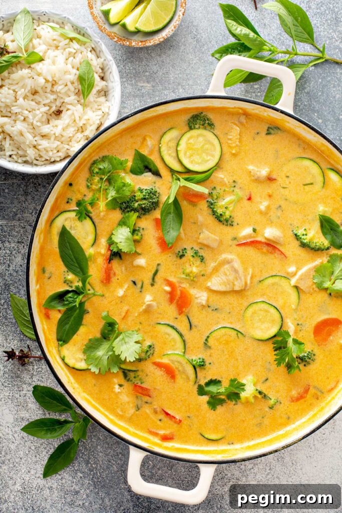 Authentic Thai Chicken Curry with Coconut Milk 5 Coconut milk red curry with vegetables in a pot next to steamed rice