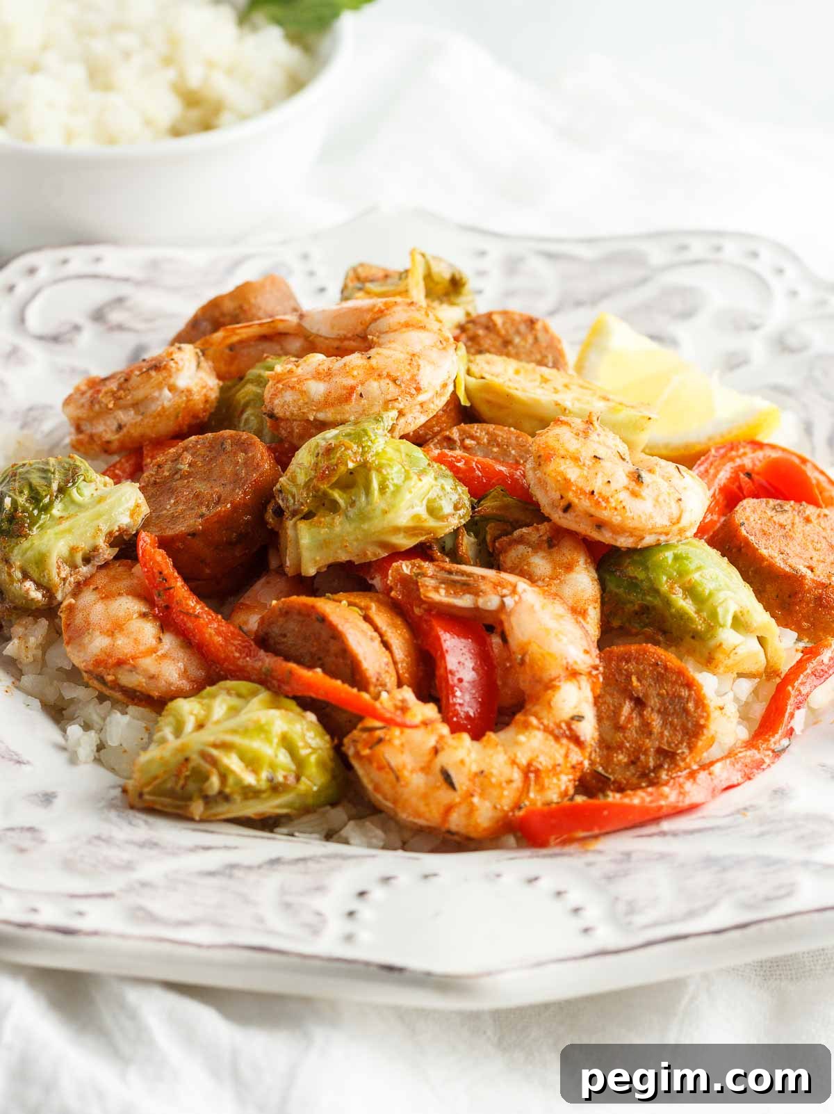 Sheet Pan Shrimp and Sausage Dinner 2 A plate of Cajun shrimp and sausage with veggies and cauliflower rice.