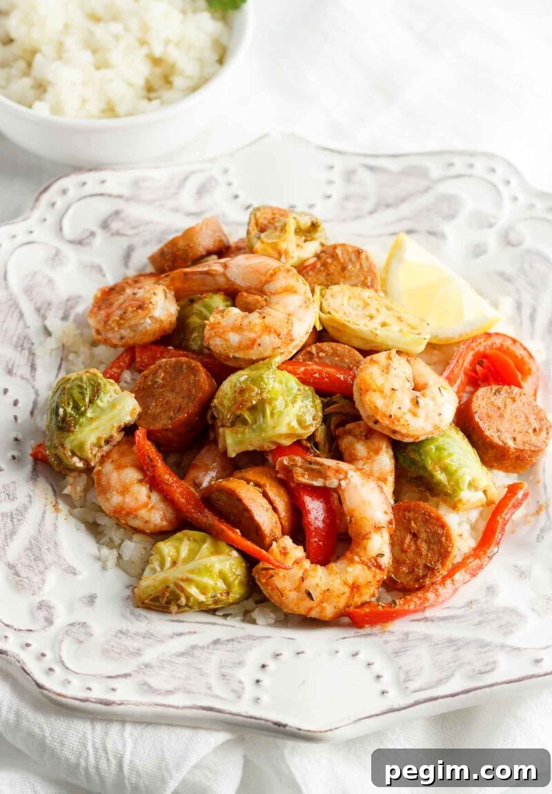 Sheet Pan Shrimp and Sausage Dinner 9 A plate of Cajun shrimp and sausage with veggies and cauliflower rice.
