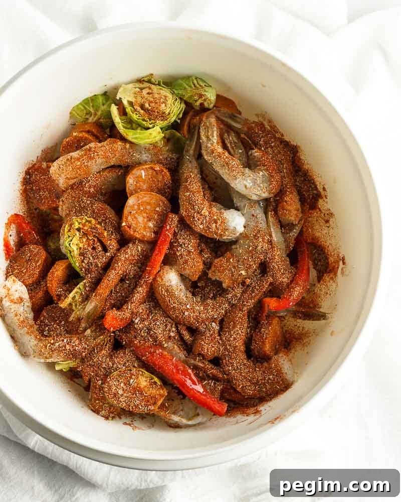 Sheet Pan Shrimp and Sausage Dinner 5 Adding spice to the mixture.