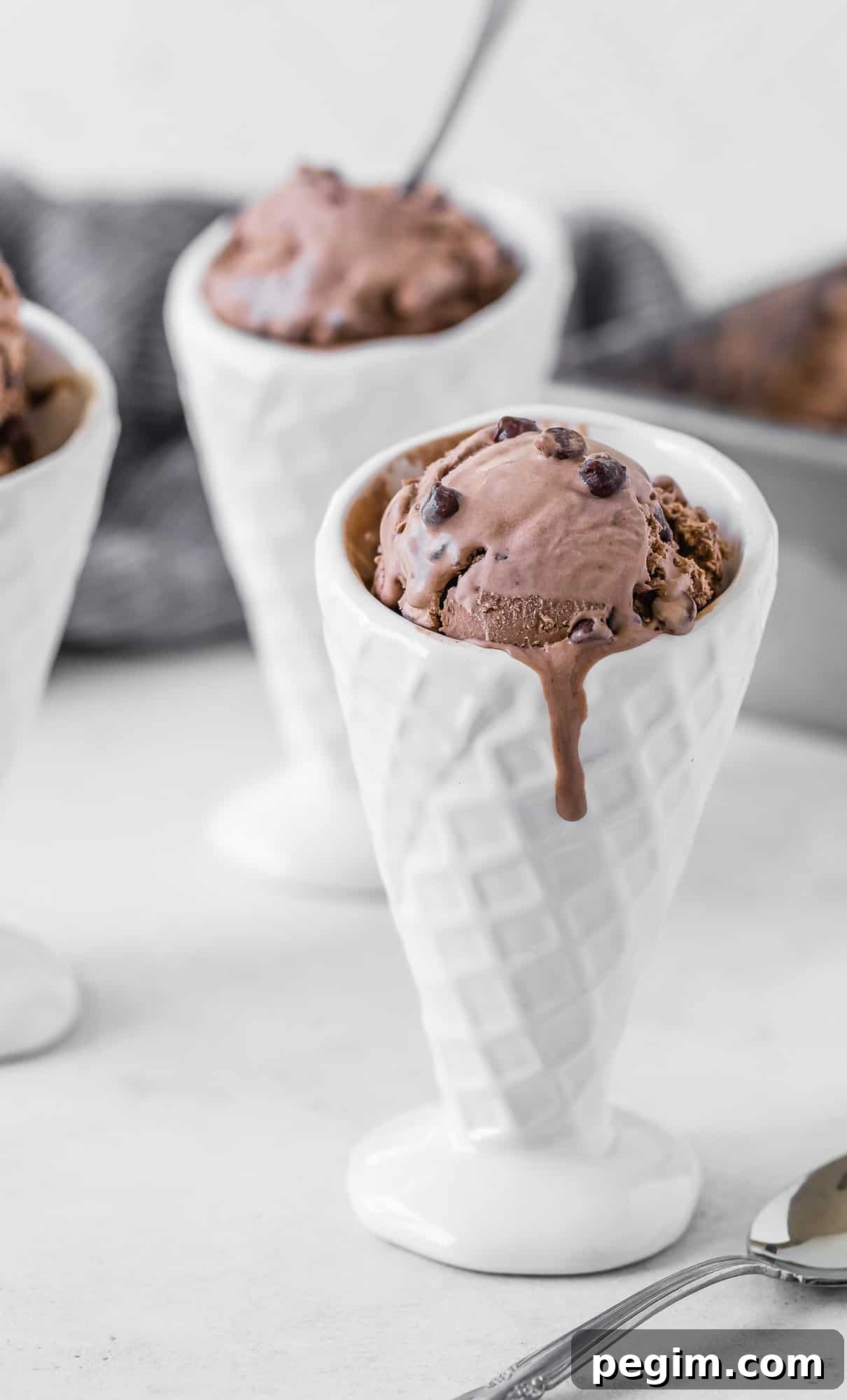Creamy and smooth homemade chocolate ice cream is easy to make without an ice cream maker! Add chocolate chips for double the chocolate. No churn double chocolate ice cream in a white ceramic cone.