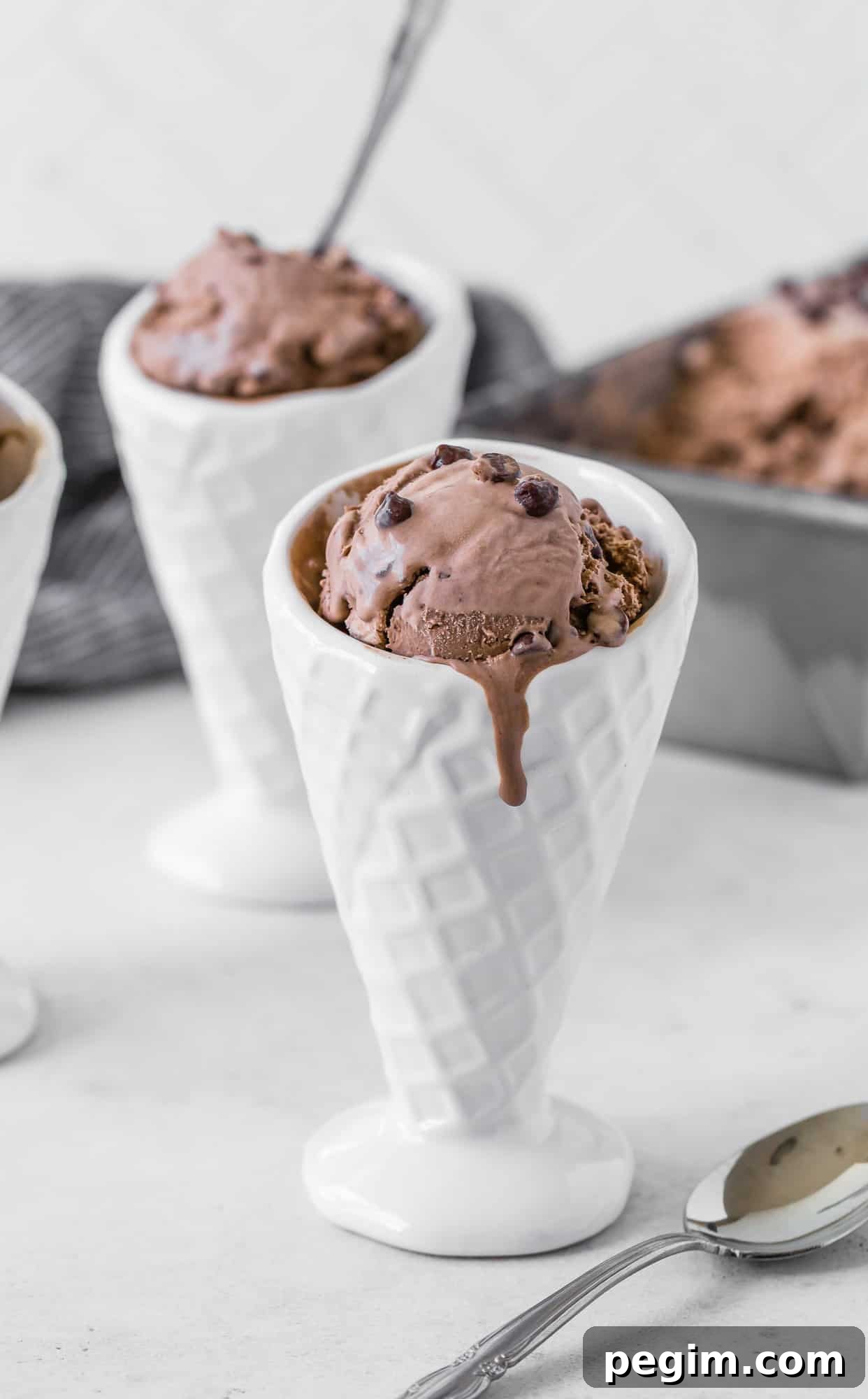 Creamy and smooth homemade chocolate ice cream is easy to make without an ice cream maker! Add chocolate chips for double the chocolate. Chocolate ice cream dripping down a white ceramic cone.