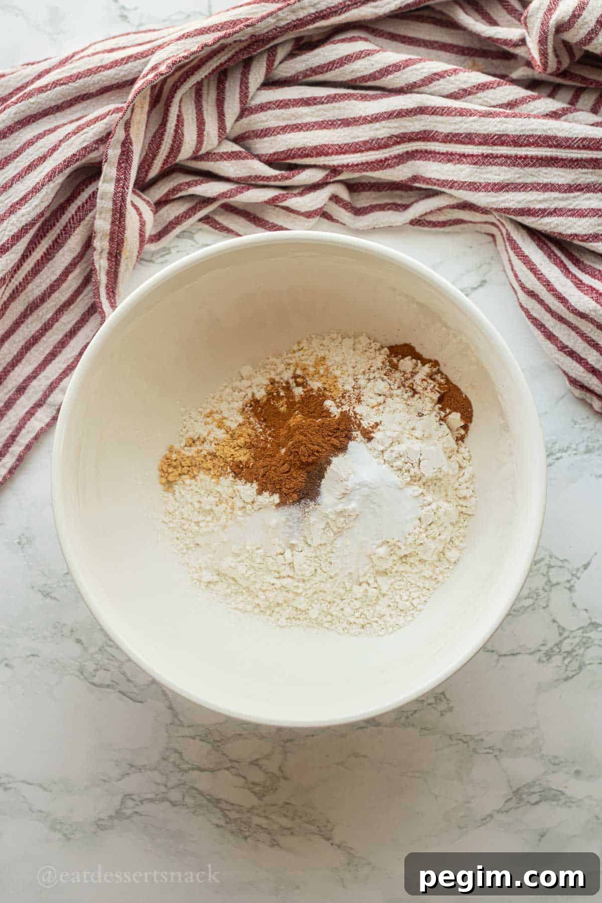 Homemade Apple Cinnamon Donuts with Spiced Glaze 5 Dry ingredients in mixing bowl.