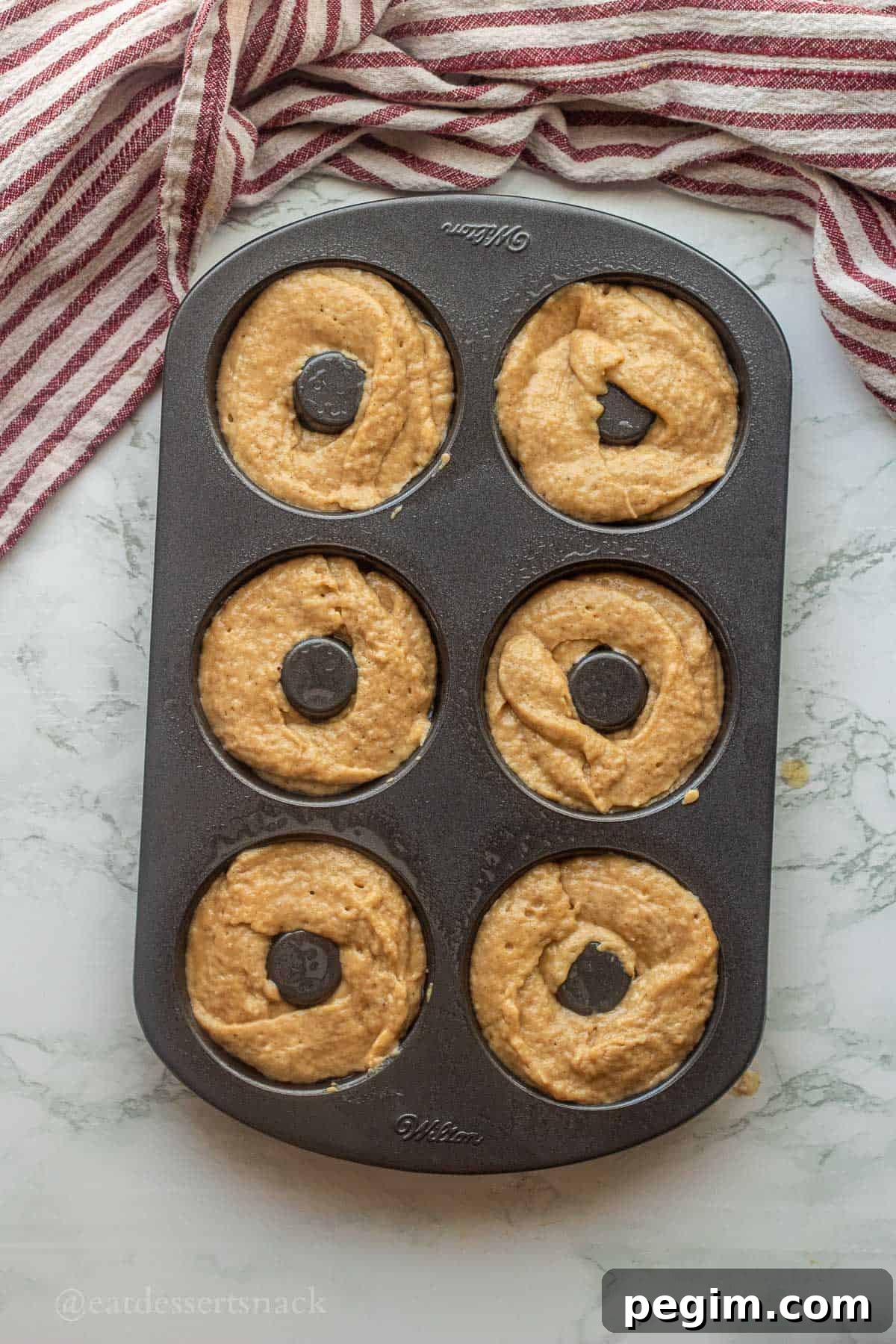 Homemade Apple Cinnamon Donuts with Spiced Glaze 8 Raw apple cider donut batter in baking pan.