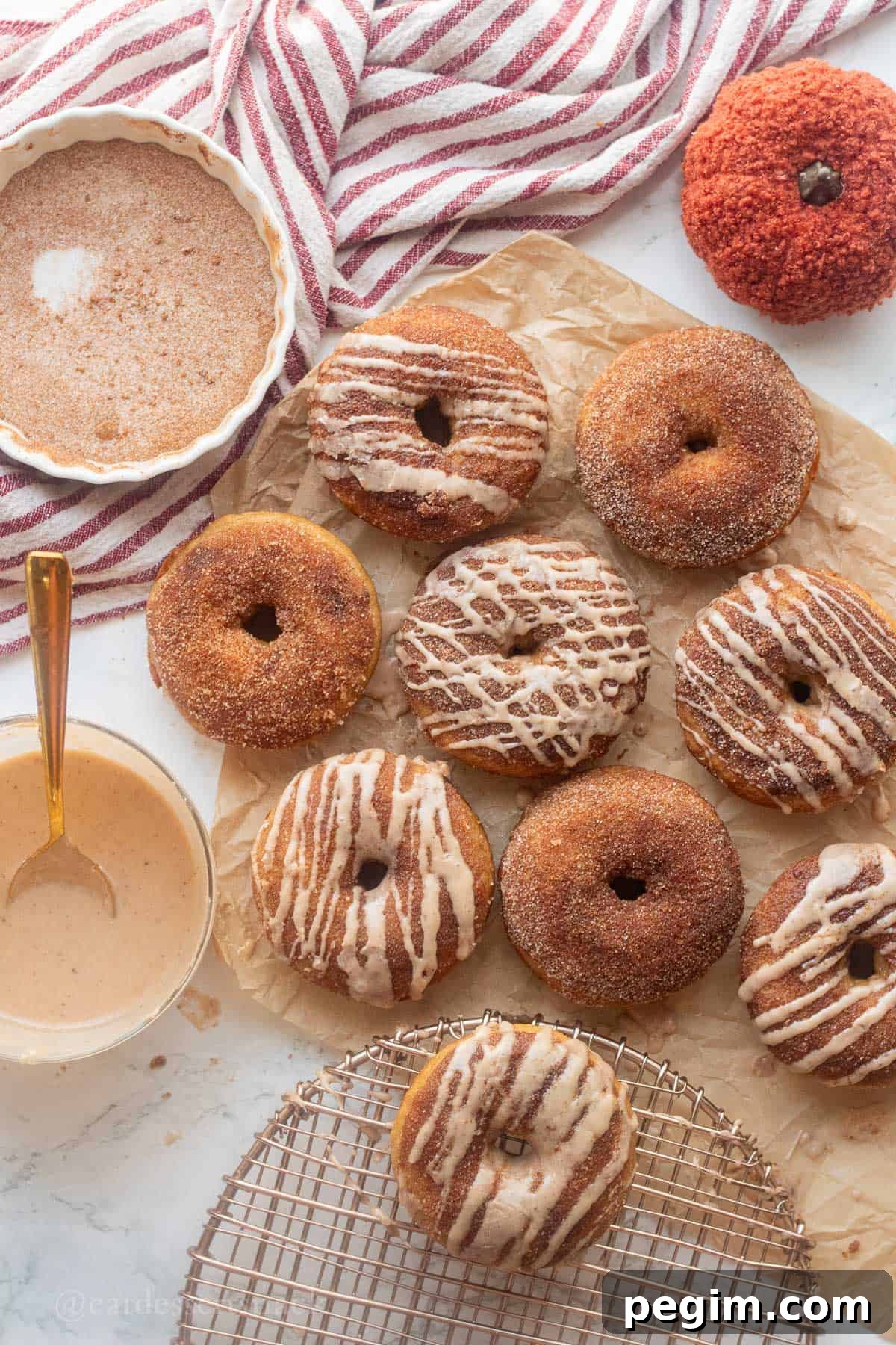 Homemade Apple Cinnamon Donuts with Spiced Glaze 10 Baked apple cider donut on parchment paper glazed and sugared.