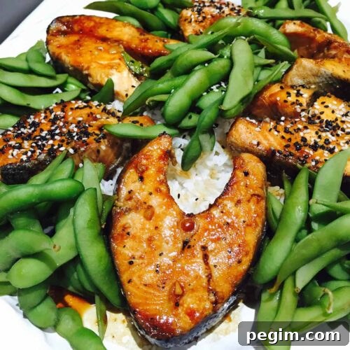 Salmon teriyaki with edamame and rice, on a white plate