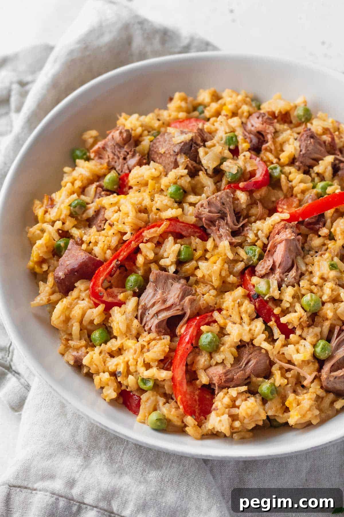 Vegan Arroz a la Valenciana: Spanish-Style Rice with Vegetables 7 A big bowl of vegan Filipino rice with sliced red bell peppers and peas.