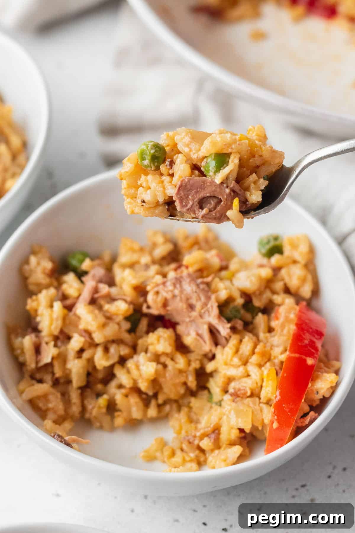 Vegan Arroz a la Valenciana: Spanish-Style Rice with Vegetables 10 A spoonful of Filipino paella being lifted up from a bowl.