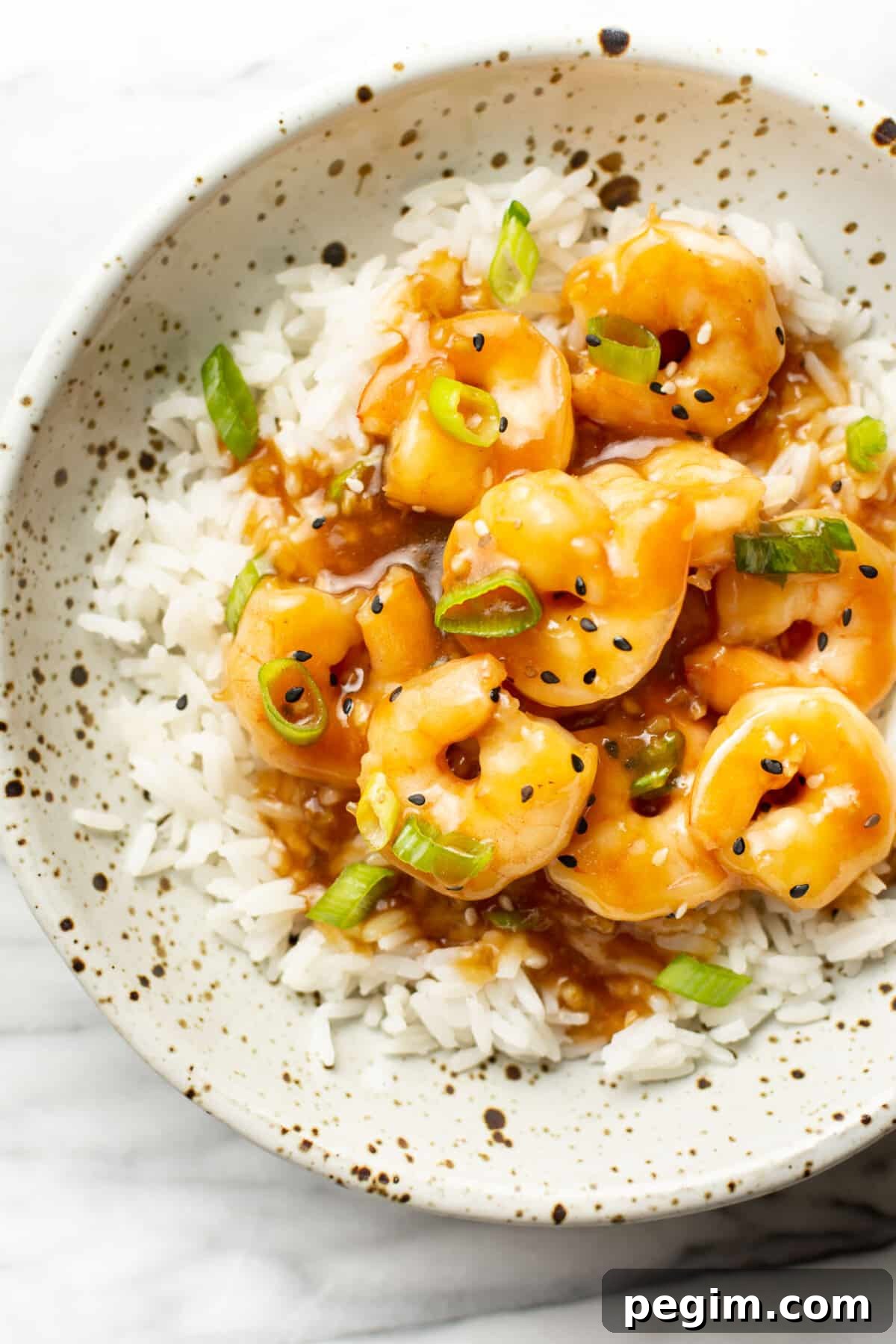 a bowl of honey garlic shrimp over rice