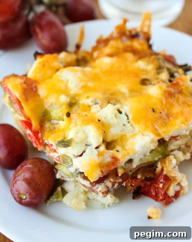 Make-Ahead Overnight Asparagus and Egg Casserole 2 egg, bacon, and asparagus casserole on a plate with grapes.